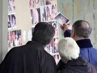 Родственники перед стендом с фотографиями погибших. Фото AFP 